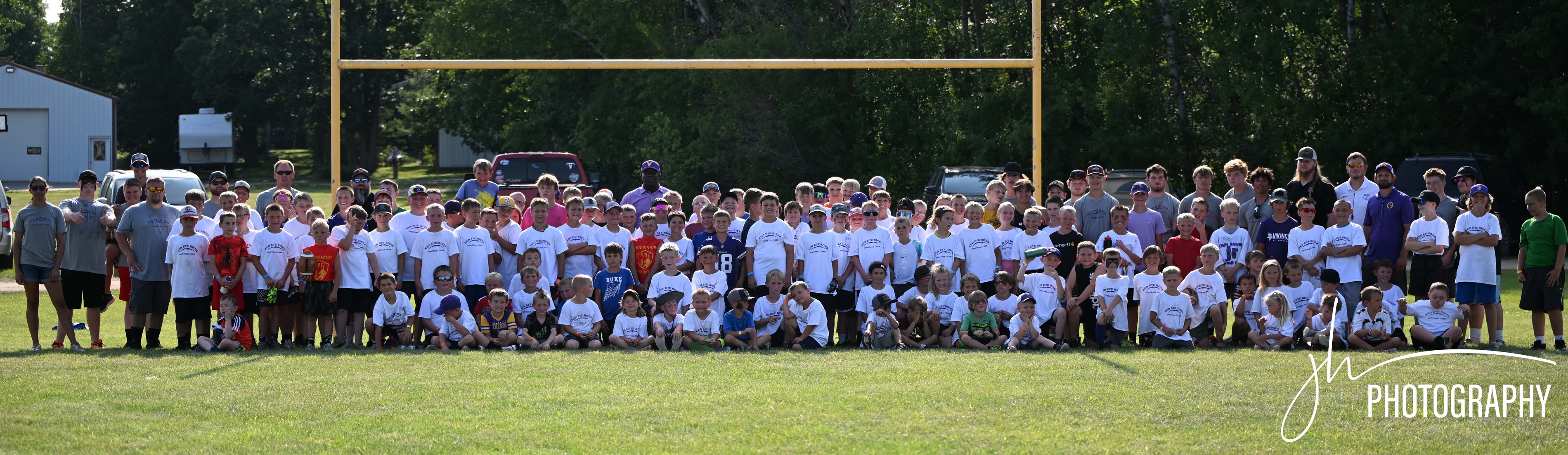 Group of athletes and coaches gathered on field